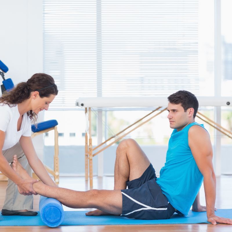 Fisioterapeuta realizando ejercicios a un hombre